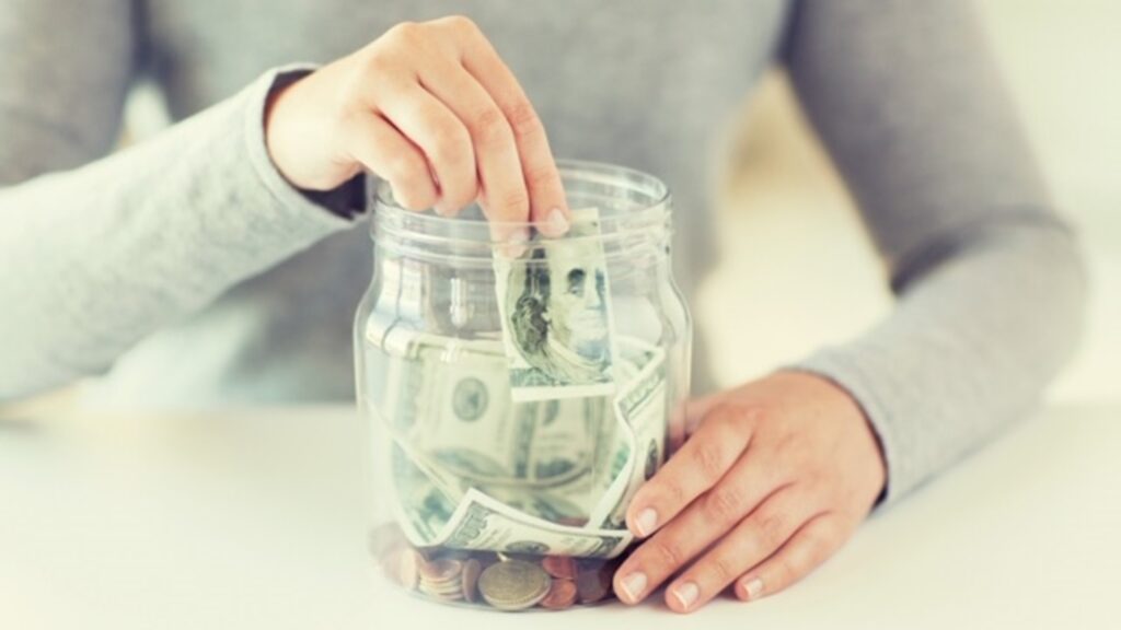 Person adds money to money jar
