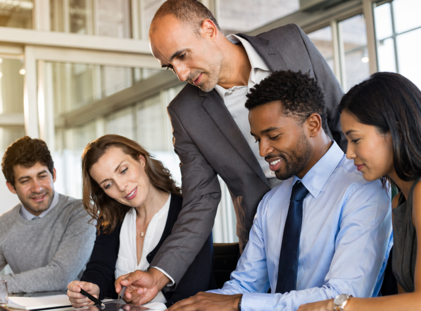 Executive discusses plans with team while looking at document