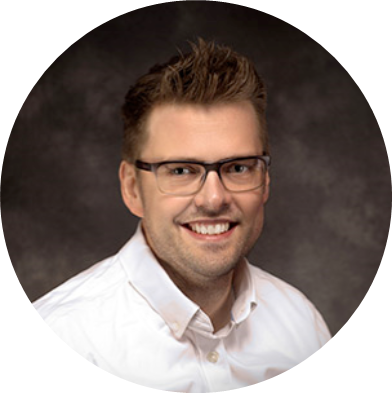 Gair Maxwell speaks in front of an audience with hands raised.